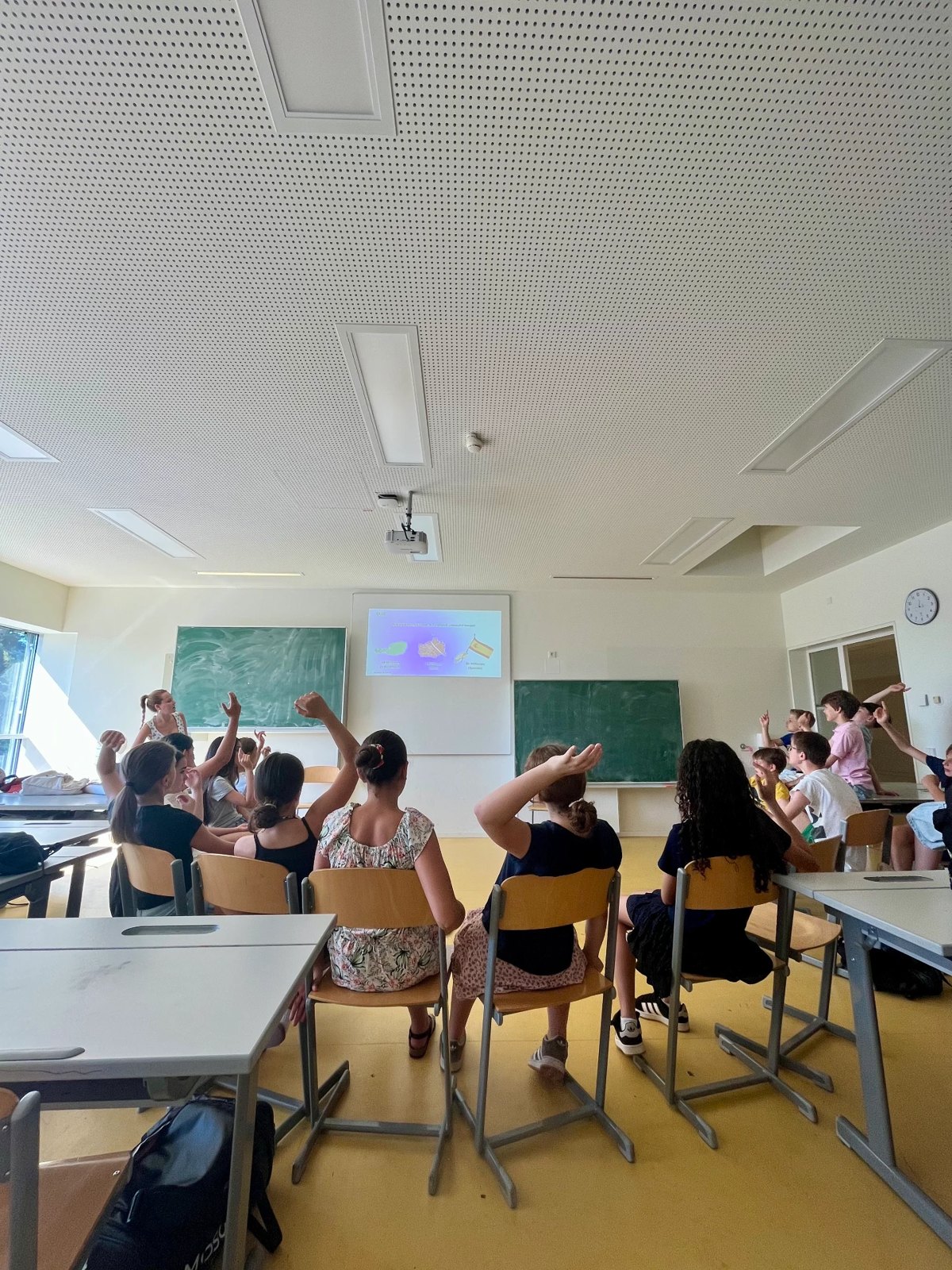 Schulklasse hebt die Hände während eines Kreislaufwirtschafts-Workshops