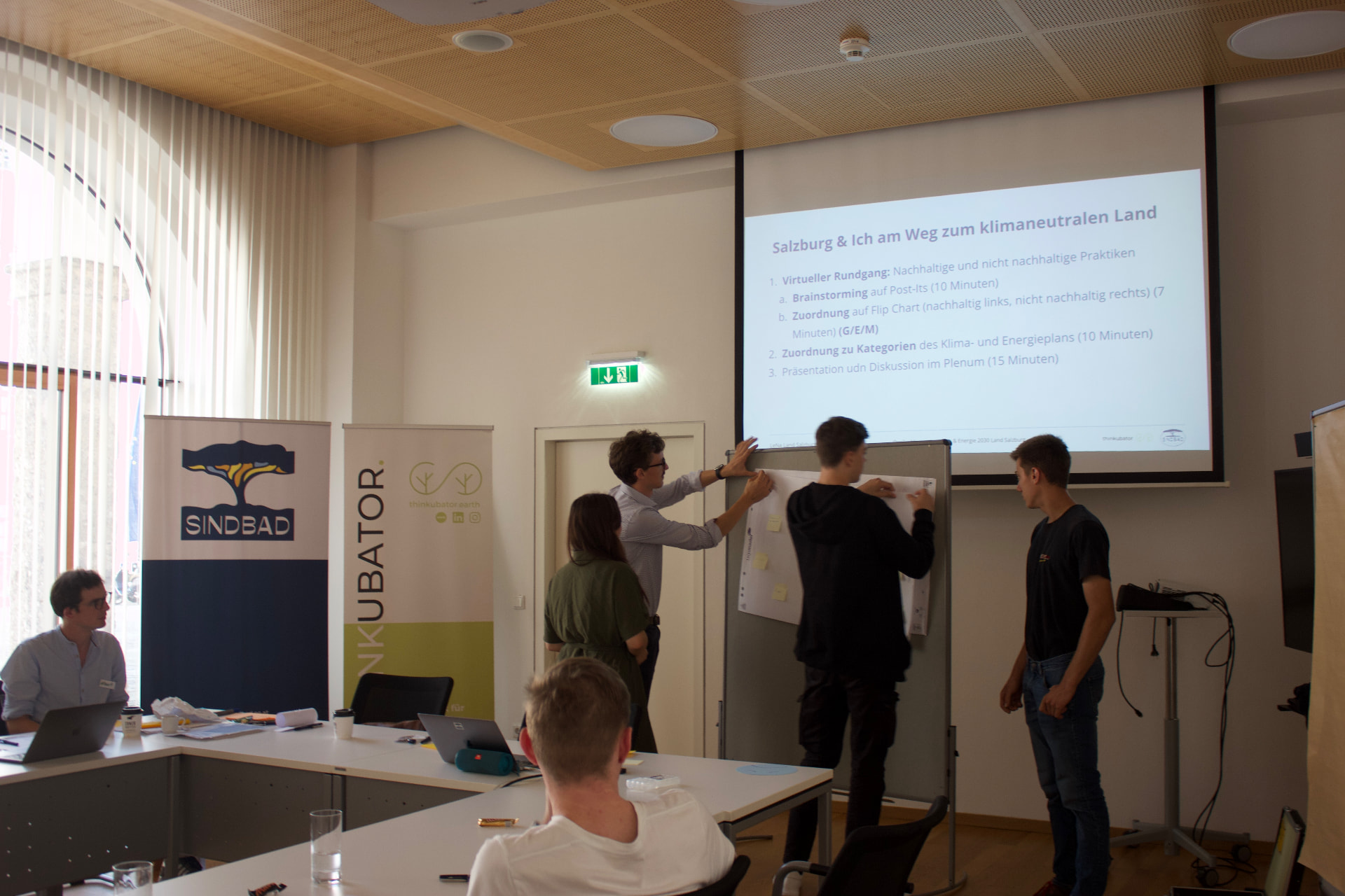 Lehrlinge ordnen Ideen auf einem Flipchart zum klimaneutralen Land Salzburg